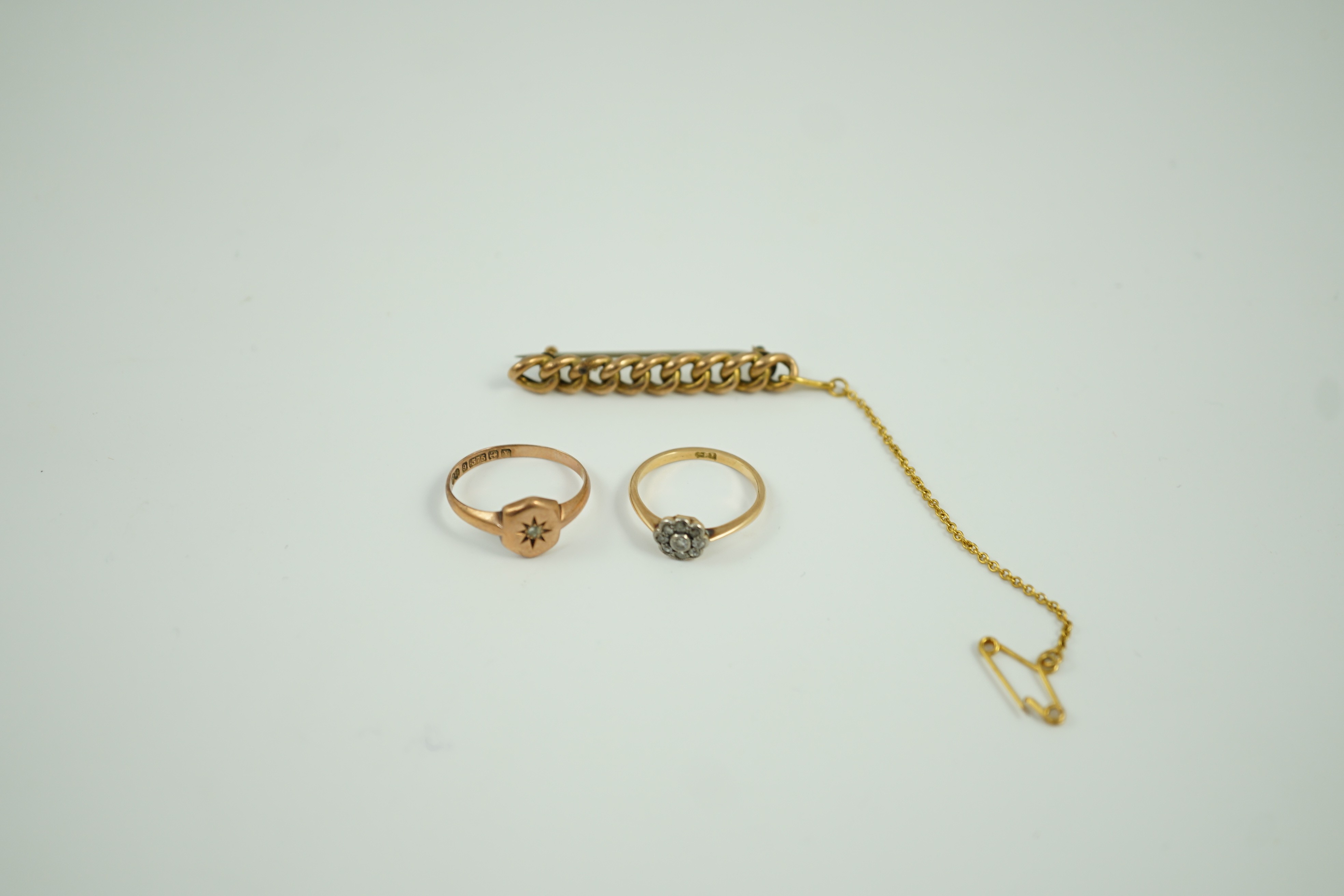 A small 18ct and diamond set cluster ring, size K, gross 1.2 grams, a 9ct gold and diamond chip set ring and a yellow metal curb link bar brooch, gross 5.1 grams.